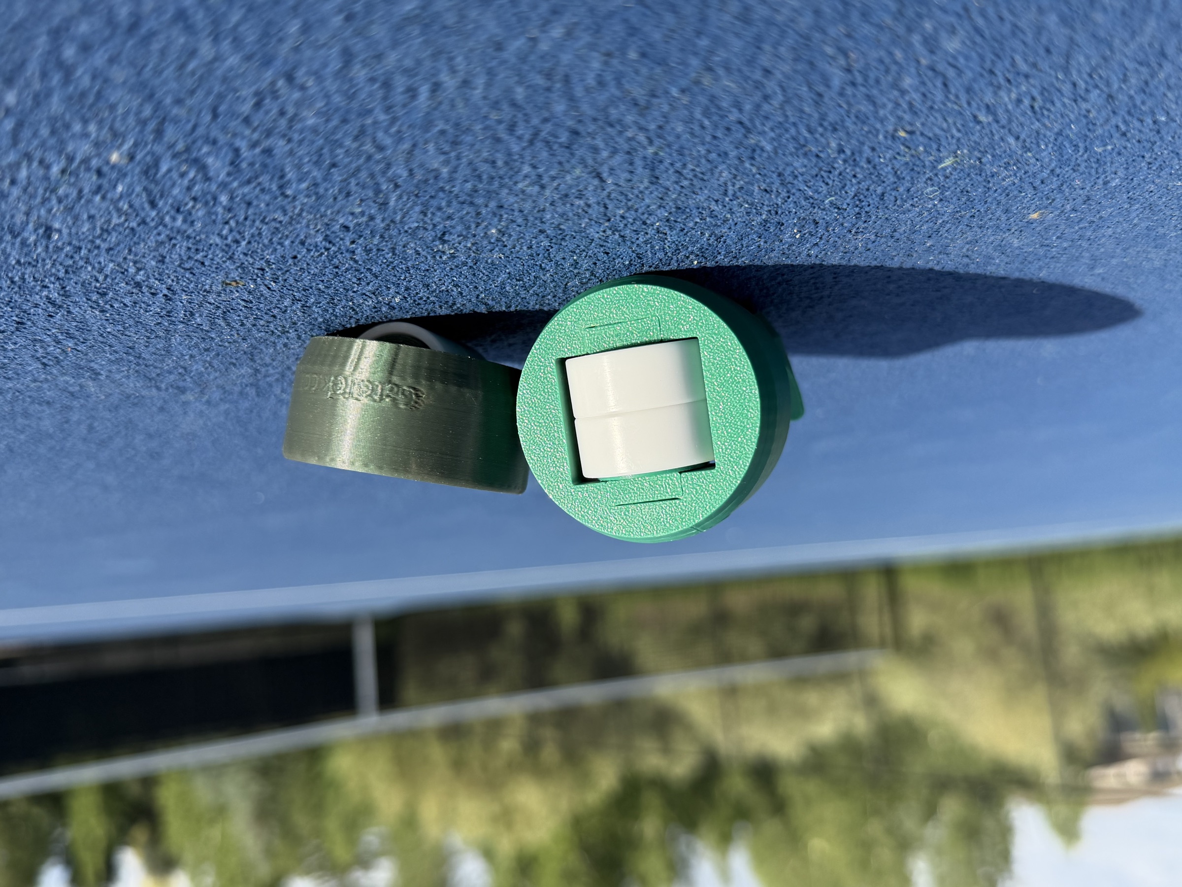 GateTek cap face-on, internal white caster wheel visible inside the green shell